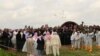 Yazidi priests release doves into the air after blessing a mass grave while the exhumation team stands by to begin their work in Kocho, Iraq, March 15, 2019. 