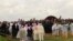 Yazidi priests release doves into the air after blessing a mass grave while the exhumation team stands by to begin their work in Kocho, Iraq, March 15, 2019. 