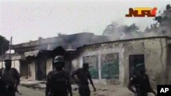 Sojoji su na wucewa ta jikin wasu gidajen da aka kona a Maiduguri, 8 Oktoba, 2012