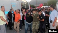 被怀疑参与未遂政变的土耳其士兵被警察押着抵达一家法院.(2016年7月17日)