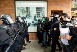 Police officers face off against protesters opposed to right-wing demonstrators following an "End Domestic Terrorism" rally in Portland, Ore., on Aug. 17, 2019.