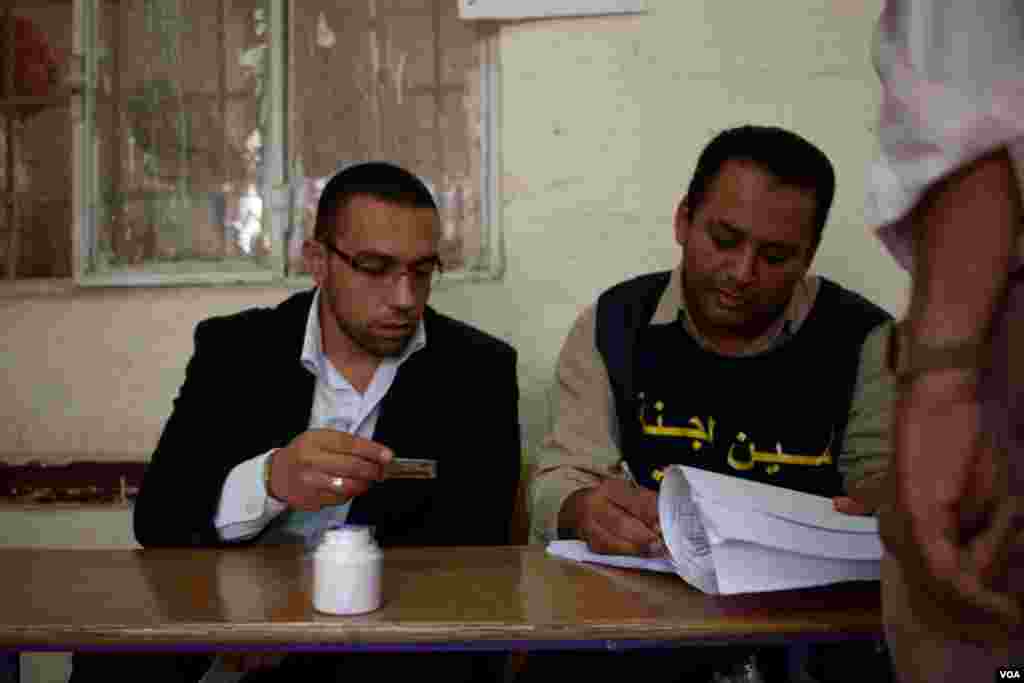 Poll workers check IDs against voter lists, Cairo, Egypt, May 23, 2012. (Y. Weeks/VOA)