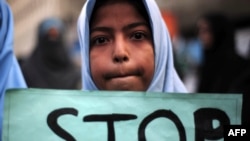 一名什叶派学生手举标语牌，抗议塔利班激进分子袭击白沙瓦一个军队管理的学校（资料图）