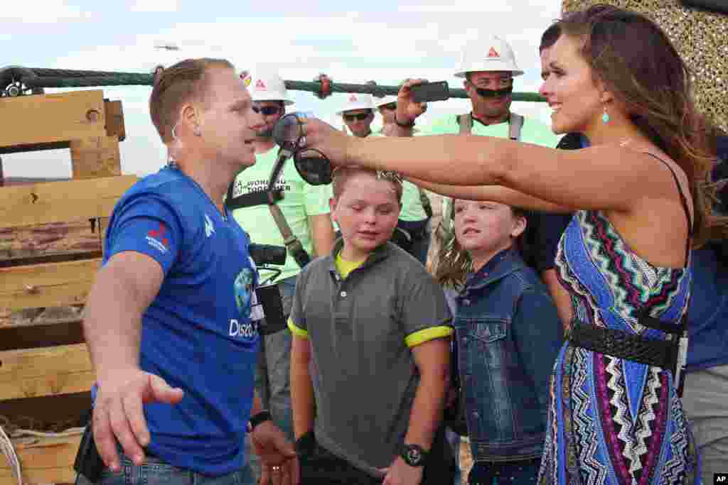 美国钢丝特技表演家尼克&middot;瓦伦达在完成走钢丝穿过大峡谷上空之后，和妻子拥抱（2013年6月23日）