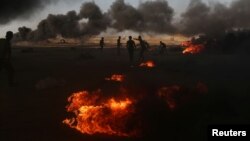 加沙地带巴勒斯坦抗议者星期一燃烧的汽车轮胎冒出浓烟