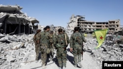 برخی از اعضای ائتلاف موسوم به نیروهای دموکراتیک سوریه در مقابل ساختمان بیمارستان شهر که کاملا ویران شده است - ۲۵ مهر ۱۳۹۶ 