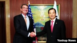 지난해 5월 싱가포르에서 열린 제14차 아시아안보회의(샹그릴라 대화)에 참석한 한민구 국방부 장관(오른쪽)과 애슈턴 카터 미국 국방장관이 미한 국방장관 회담에 앞서 악수하고 있다. (자료사진)