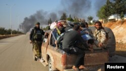 지난달 30일 시리아 반군이 알레포 서부 다히예트 알-아사드 지역에서 피난민들을 픽업 트럭에 태우고 퇴각하고 있다.