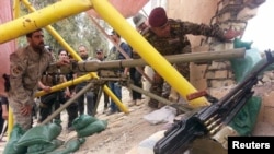 Pasukan keamanan Irak dan pejuang kesukuan bersiap menyerang militan ISIS di jembatan al-Houz di Sungai Efrat, Ramadi, Irak (24/4).