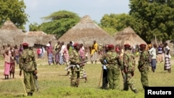 Police officers stand guard following a fresh attack at Kipao village in Tana River district in Kenya's coastal Tana Delta region, December 22, 2012.