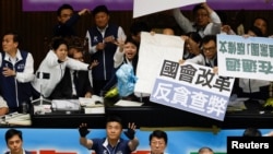 资料照片：台湾最大反对党国民党的立法委员试图阻挡民进党立法委员投掷的塑料袋，其中一些塑料袋上写有 “垃圾”字样。(2024年5月28日)