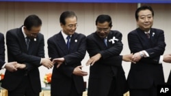 From left: South Korea's President Lee Myung-bak, China's Premier Wen Jiabao, Cambodia's Prime Minister Hun Sen and Japan's Prime Minister Yoshihiko Noda prepare to join hands together for a group photo during the ASEAN Plus Three (APT) Commemorative Summit in Phnom Penh, Cambodia, Monday, Nov. 19, 2012. (AP Photo/Vincent Thian)