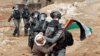 A Palestinian demonstrator scuffles with an Israeli border police member during a protest against Jewish settlements and U.S. President Donald Trump, in Beit Dajan in the Israeli-occupied West Bank, Nov. 6, 2020. 