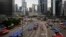 Pro-democracy protesters walk outside tents set up on a main road leading the the financial Central district in Hong Kong, October 10, 2014.