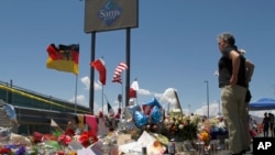 在这张2019年8月12日拍摄的照片中，哀悼者站在德克萨斯州埃尔帕索沃尔玛附近的临时纪念碑前，那里有22人在大规模枪击事件中丧生。两年前，一名枪手针对拉丁裔人开枪，最终造成23人死亡，震惊了美国和墨西哥。（美联社资料照）