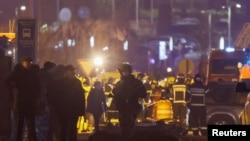 枪击事件发生后，专业人员聚集在名为“番红花市政厅”的音乐厅附近的死难者旁边。(2024年3月22日)