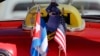 The stars and stripes and the Cuban national flag are placed together on the dashboard of a vintage American convertible in Havana, Cuba, Feb. 18, 2016.