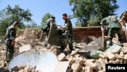 Para petugas kepolisian tengah berupaya melakukan pencarian korban diantara ruruntuhan rumah pasca gempa berkekuatan 6.6 mengguncang wilayah Minxian, Dingxi, provinsi Gansu, China (22/7).