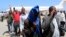 FILE- Deported Somali nationals gesture as they arrive at the airport in Somalia's capital of Mogadishu, April 9, 2014. Sixty-eight Somalis arrived in Magodishu Friday, having been deported by U.S. immigration authorities.