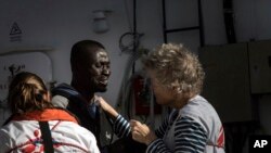 Des travailleurs de MSF consolent un migrant en sanglots à bord du MV Aquarius où 193 personnes et deux cadavres ont été récupérés à environ 22 milles au nord de Sabrata, au large de la Libye, le 13 janvier 2017.