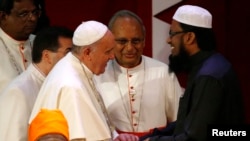 Paus Fransiskus berjabat tangan dengan pemimpin Muslim Sri Lanka, Maulavi Ash-Sheikh M.F. M. Fazil dalam pertemuan lintas agama di Kolombo (13/1). (Reuters/Stefano Rellandini)