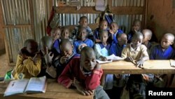 FILE - A class of children between the ages of six and seven years old pose for pictures in their classroom at Gifted Hands Educational Center in Kenya's Kibera neighborhood in the capital Nairobi, September 2015.