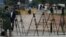FILE - Pakistani journalists are seen at a stake-out in Islamabad, Pakistan, Nov. 6, 2013. Recently, a Pakistani government body, established to regulate private TV channels, has started asserting itself in ways that have raised concerns with media watchdogs.