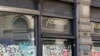 A man walks next to the windows of a closed shop in downtown Milan, Italy, April 12, 2012. 