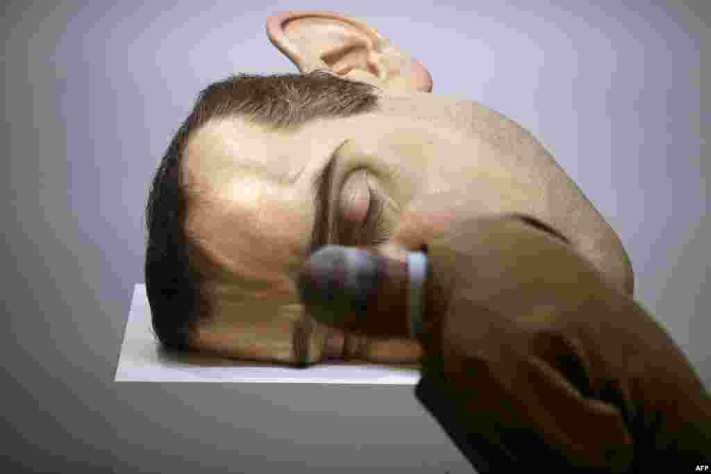 Seorang pria mengamati patung &quot;Mask II&quot; karya seniman Australia Ron Mueck yang sedang dipamerkan di kota Paris.
