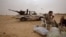 FILE - Libyan soldiers take a break from fighting with militants on the front line in Al Ajaylat, 120 kilometers (75 miles) west of Tripoli, in this Feb. 21, 2015, photo.