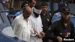 Police escort blindfolded Muslim cleric Khalid Jadoon as he is brought before a judge at a court in Islamabad, September 2, 2012.