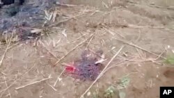 This image taken from video Dec. 7, 2021, shows bloodstains on the ground near several charred corpses in the town of Done Taw, in Myanmar's Sagaing region.