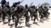 FILE - Hundreds of newly trained al-Shabab fighters perform military exercises in the Lafofe area, south of Mogadishu, Somalia.
