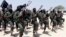 FILE - Hundreds of newly trained al-Shabab fighters perform military exercises in the Lafofe area some 18 km south of Mogadishu, in Somalia. 
