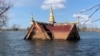 A curving roof of a small wooden pagoda juts above the water line in Srekor village of Stung Treng province, which has been affected flooding caused by Lower Sesan 2 Dam, Nov 28, 2018. (Sun Narin/VOA Khmer)