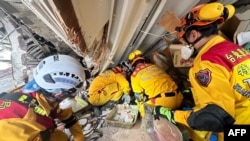 台湾消防署提供的照片显示，消防人员正在寻找地震被困人员。