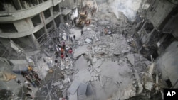 Wapalestina wakikagua uharibifu uliofanywa na mashambulizi ya Israeli katika vita inayoendelea huko Gaza.