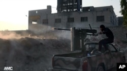 Seorang pemberontak Suriah menembakkan senjatanya ke arah pasukan setia Presiden Bashar Assad di Aleppo, Suriah (9/11). Kedua pihak telah sepakat untuk melonggarkan blokade di kota Qudsaya.