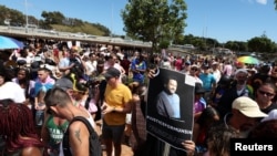 Un participant à la Cape Town Pride à Green Point tient une pancarte arborant l’image du Sud-Africain assassiné Muhsin Hendricks, considéré comme le premier imam ouvertement gay au monde, au Cap, en Afrique du Sud, le 1er mars 2025.