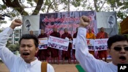 Myanmar nationalist Buddhist monks display placards as demonstrators shout slogans during a protest rally against a Thai court's verdict sentencing two Myanmar migrant workers to death, in Yangon, Myanmar, Dec. 29 2015.