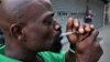 A man smokes a mixture of heroin and cocaine outside a train station in the Kensington neighborhood of Philadelphia, Aug 17, 2017.