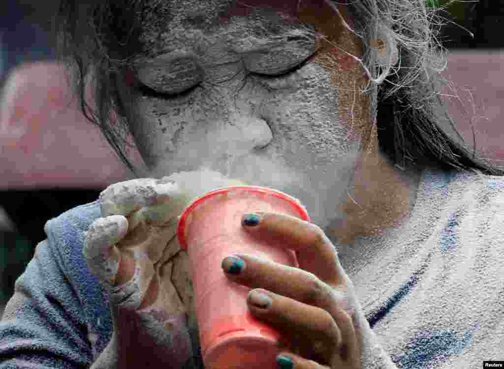 Wajah seorang gadis diselimuti bubuk putih setelah meniupkannya selama penyelenggaraan festival keagamaan yang menghormati santa pelindung Santa Rita de Cascia di Parnaque City, Metro Manila, Filipina.