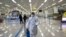 State Commission of Quality Management staff member in protective gear carries a disinfectant pray can as they continue to check the health of travelers and inspect and quarantine goods at the Pyongyang Airport in Pyongyang, North Korea, Feb. 1, 2020.