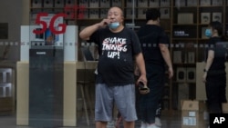A Chinese man looks out near a Huawei store promoting 5G services in Beijing on Wednesday, July 22, 2020. The United States and Britain have put on a show of unity against the Chinese telecoms giant Huawei, as Secretary of State Mike Pompeo…