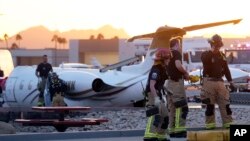 Firefighters work around the site of a crashed Learjet at Scottsdale Airport after it collided with a parked plane Feb. 10, 2025, in Scottsdale, Ariz. 