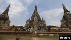 FILE - Tourists walk at the ruins of the ancient capital of Ayutthaya, Thailand.
