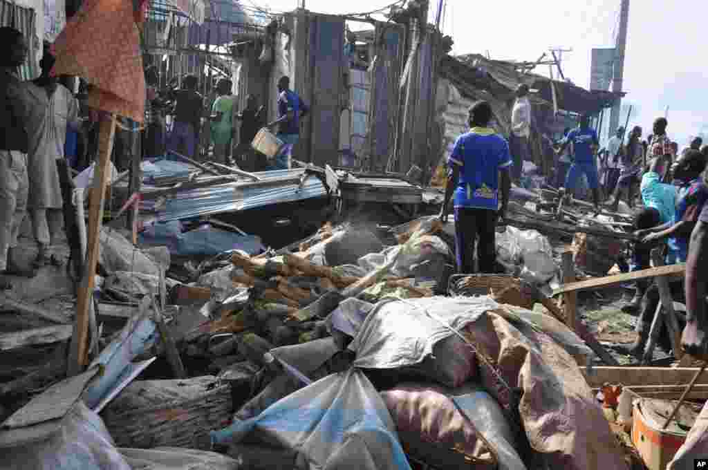 People gather at the scene of a car bomb explosion at the central market, Maiduguri, Nigeria, July 1, 2014.