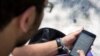FILE - A man uses his smartphone in Tehran, Iran.