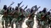 FILE - Al-Shabab fighters march with their weapons during military exercises on the outskirts of Mogadishu, Somalia, Feb. 17, 2011. Kenyan authorities said fighters carried out the cross border attack early Thursday on a police station at Hameey village, Sept. 22, 2016.