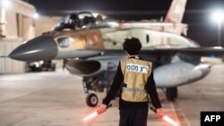 این تصویر که ارتش اسرائیل در ۵ آبان ۱۴۰۳ منتشر کرد، یک جنگنده اسرائیلی را در حال خارج شدن از یک آشیانه در مکانی نامعلوم در اسرائیل نشان می‌دهد.